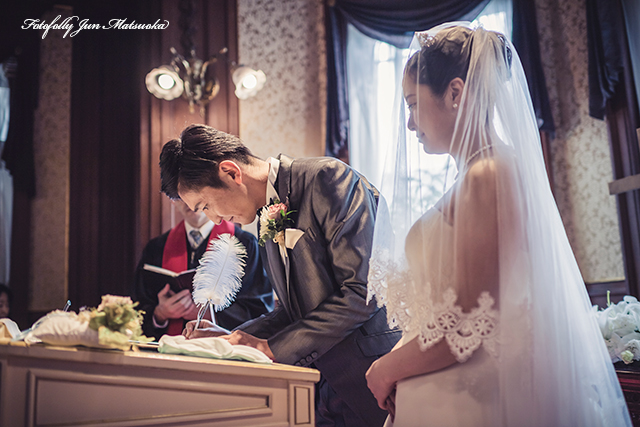 グランドプリンスホテル高輪ウエディングフォト ブライダルフォト 結婚式写真 挙式誓約書にサインする新郎